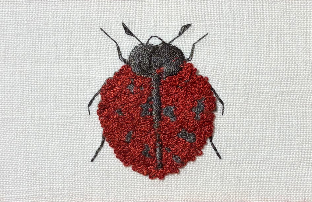 Embroidered Ladybug surrounded by Schumacher Queen B Custom Fabric Mat