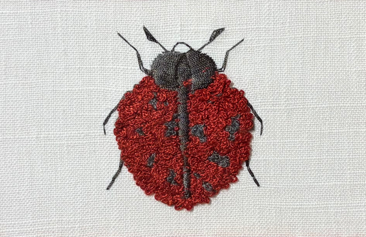 Embroidered Ladybug surrounded by Schumacher Queen B Custom Fabric Mat