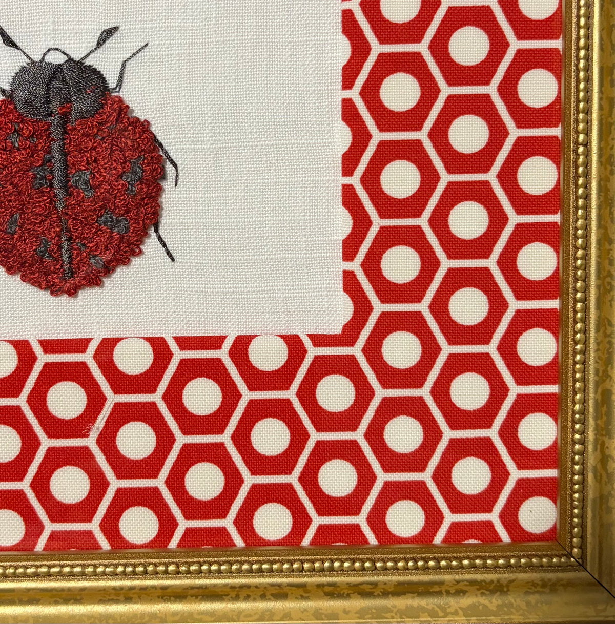Embroidered Ladybug surrounded by Schumacher Queen B Custom Fabric Mat