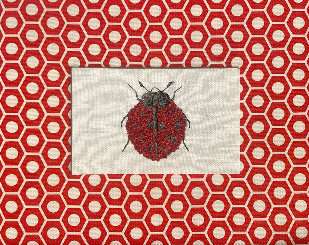 Embroidered Ladybug surrounded by Schumacher Queen B Custom Fabric Mat