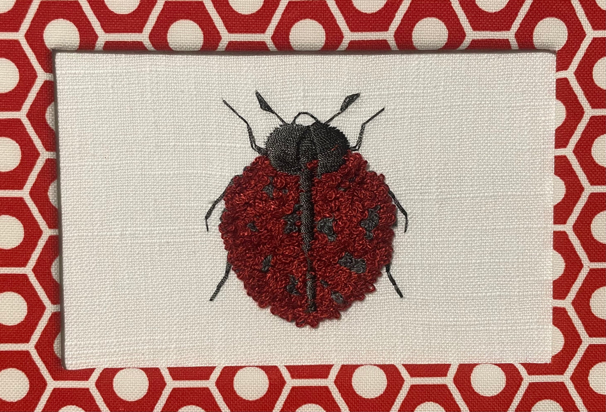Embroidered Ladybug surrounded by Schumacher Queen B Custom Fabric Mat