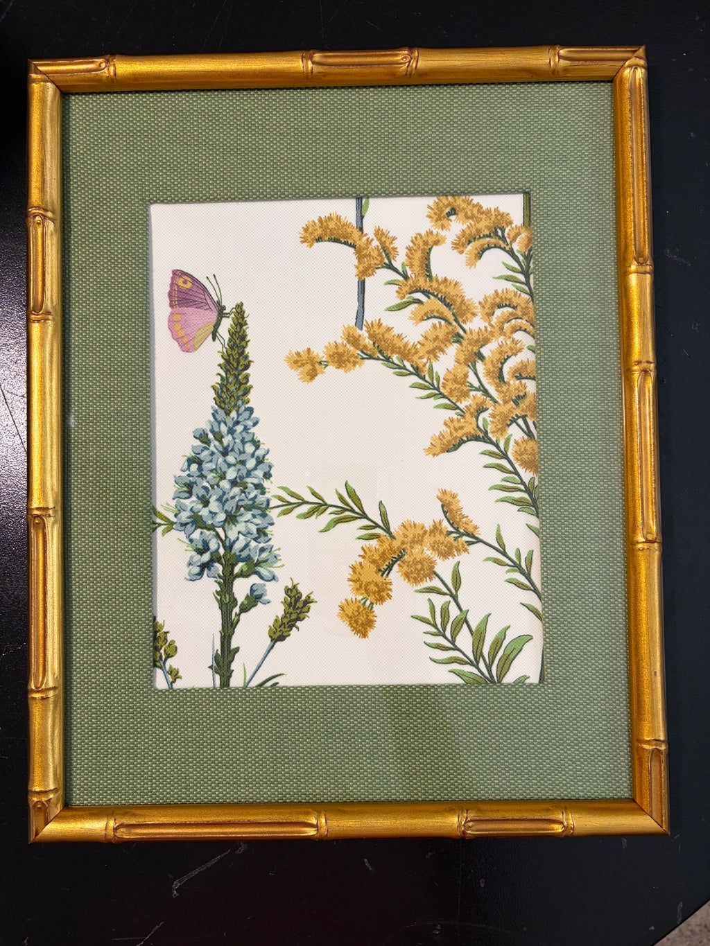 Full butterfly and blue floral Isabella artwork in a green fabric mat and gold bamboo-style frame against a dark background.