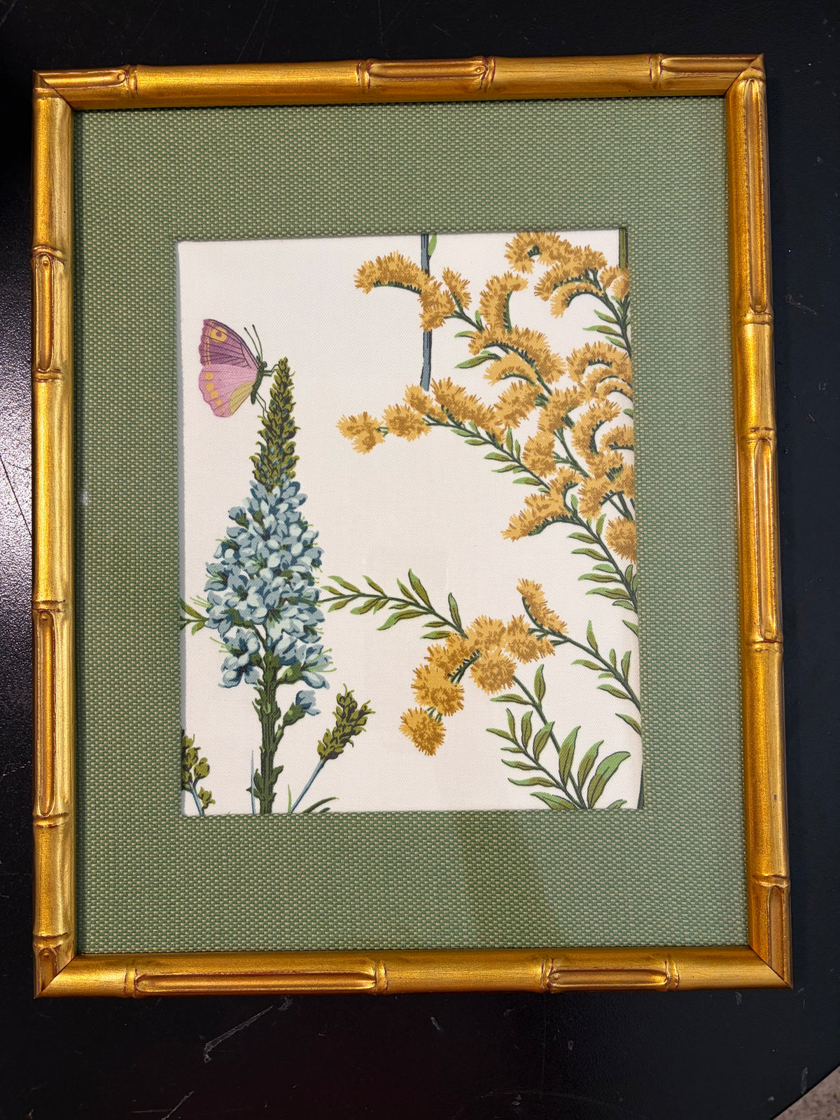 Full butterfly and blue floral Isabella artwork in a green fabric mat and gold bamboo-style frame against a dark background.