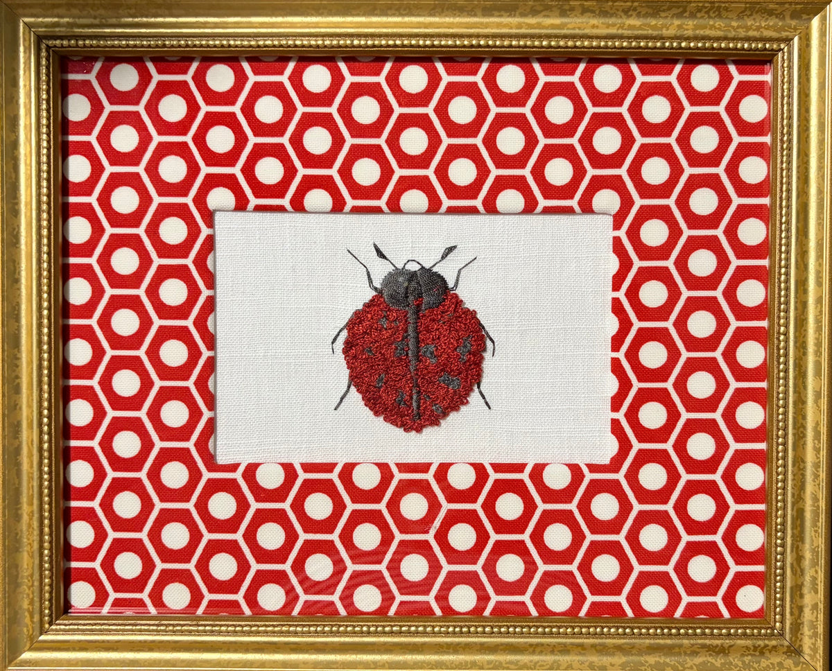 Embroidered Ladybug surrounded by Schumacher Queen B Custom Fabric Mat