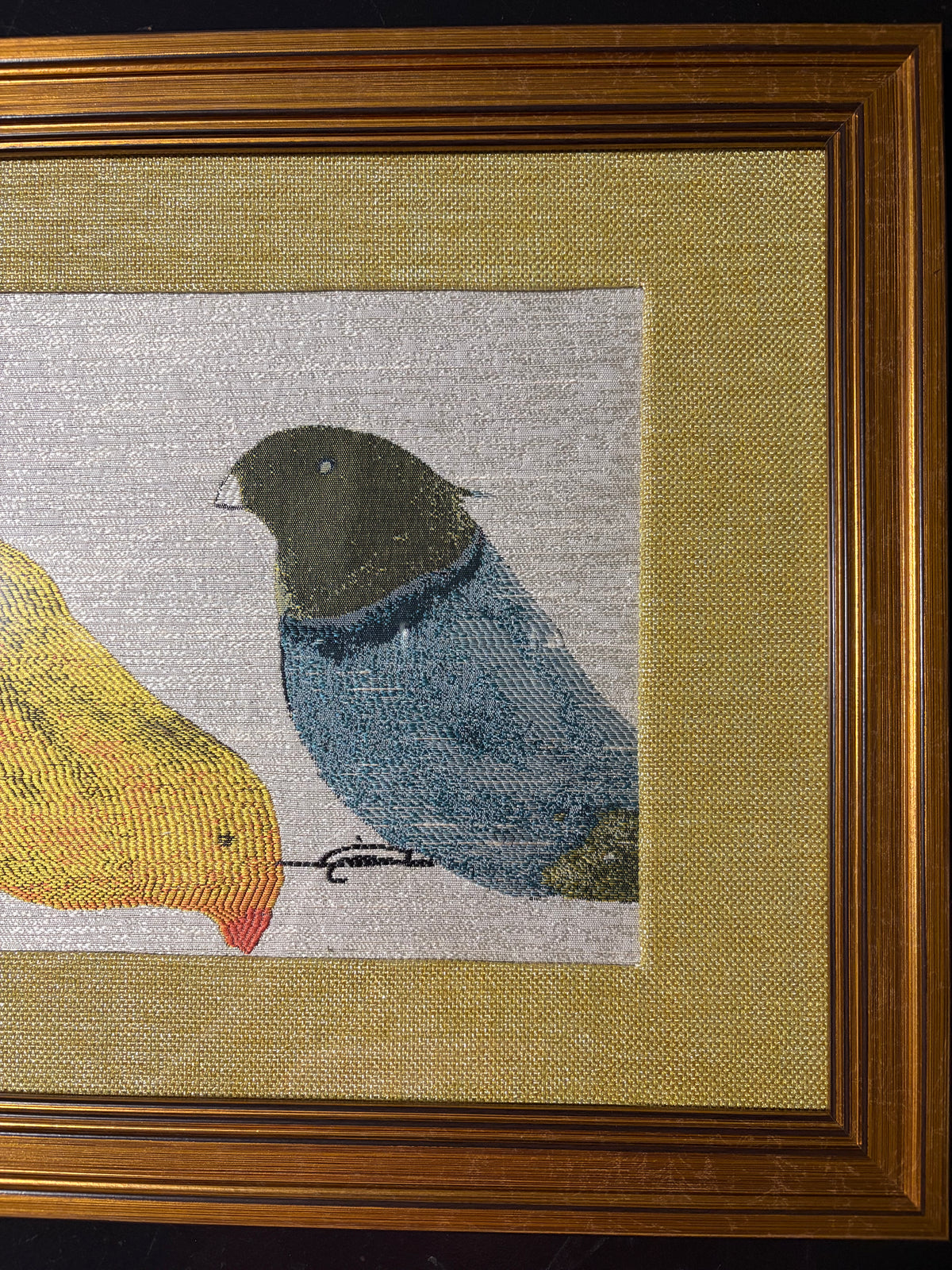 Right-side detail of the blue woven bird with dark head, gold-toned fabric mat and ridged gold-finish frame.