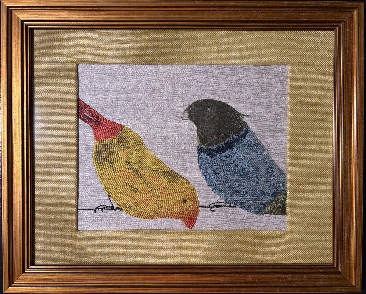 Yellow and blue woven birds on pale fabric with a custom-made gold-toned fabric mat and gold-finish frame.