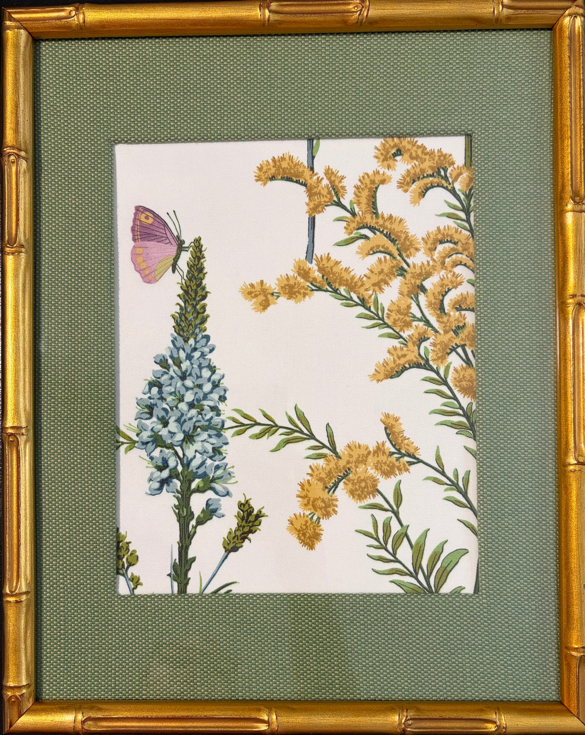 Isabella fabric artwork with a purple butterfly, blue and yellow flowers, custom-made Callen Green mat and gold bamboo-style frame.