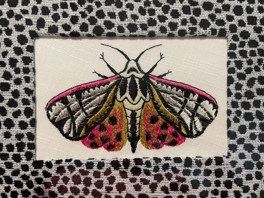 Embroidered Butterfly Moth surrounded by Ballard Designs Tully Ebony Fabric Mat