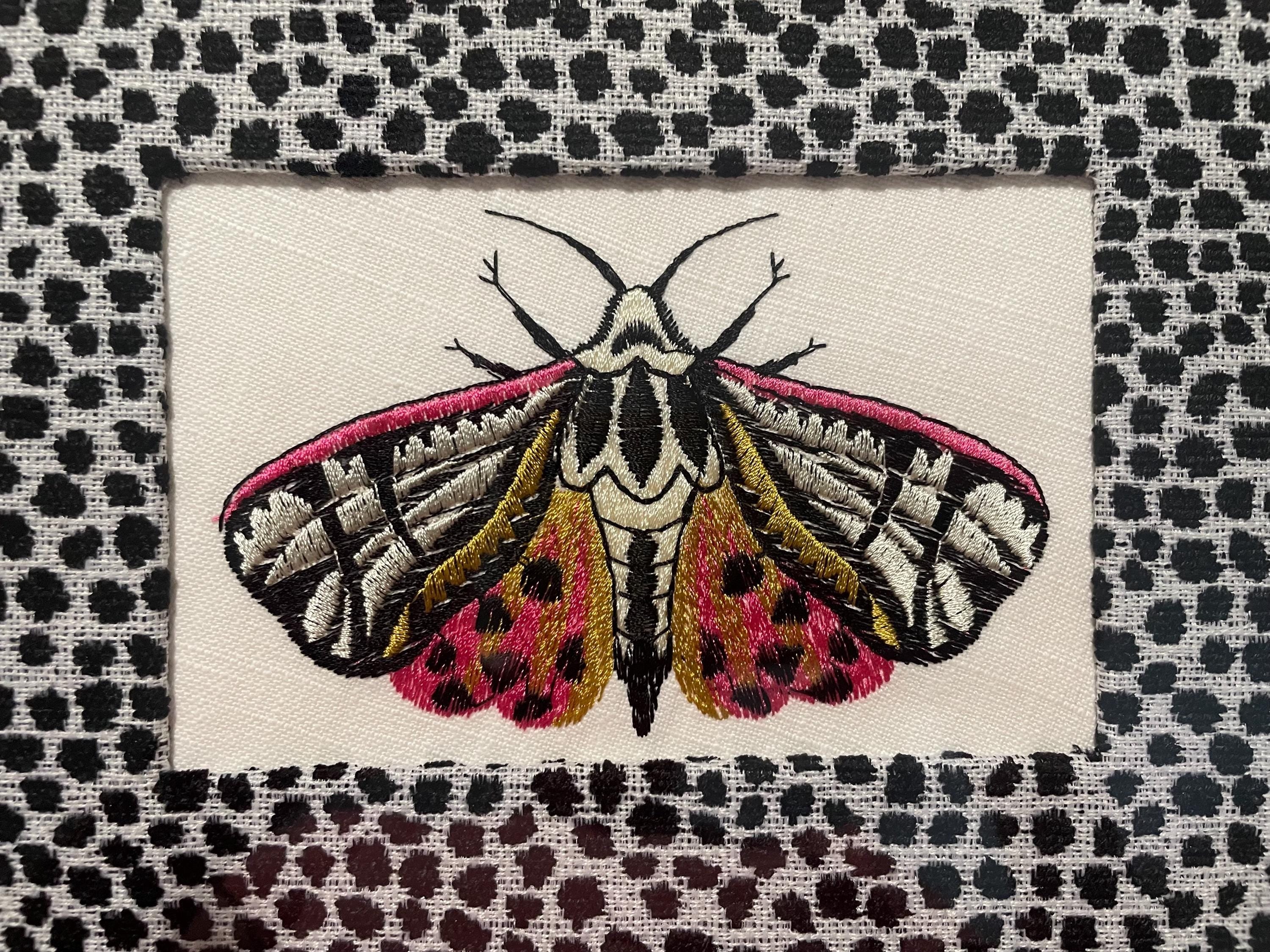 Embroidered Butterfly Moth surrounded by Ballard Designs Tully Ebony Fabric Mat