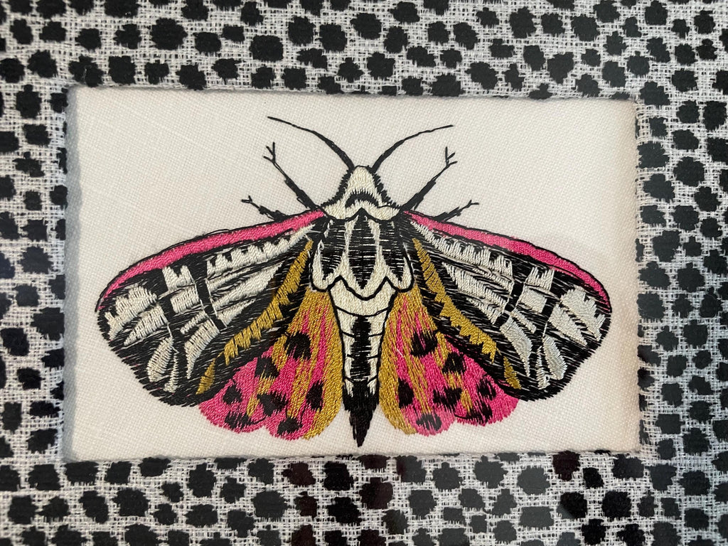 Embroidered Butterfly Moth surrounded by Ballard Designs Tully Ebony Fabric Mat