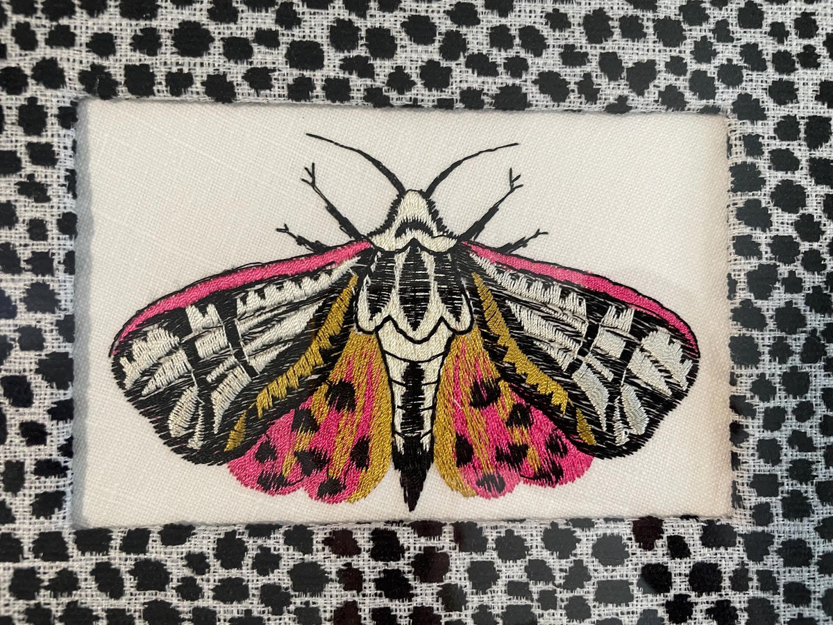 Embroidered Butterfly Moth surrounded by Ballard Designs Tully Ebony Fabric Mat